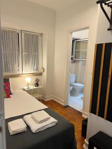 a bedroom with a bed and a bathroom with a toilet at Alvalade II Airport Guest House in Lisbon +132 photos