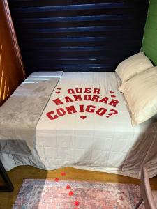a bed with a white comforter with the words never malaria anymore at Cabana estilo Glamping com Banheiras Quente e Vista às Montanhas in Rio do Sul +13 photos