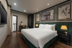 a bedroom with a large white bed and a flat screen tv at Embrace Boutique Hanoi Hotel in Hanoi