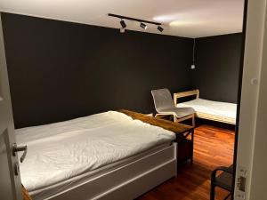 a bedroom with two beds and a chair in it at Large Room with Balcony -two storey condo- nearby Scandic Business Center bus stop in Stavanger