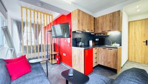 a living room with a couch and a red kitchen at House on the Top in Patra