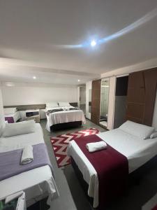 a hotel room with three beds and a room with at Pousada Bahia Morena in Salvador