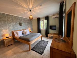 a bedroom with a bed and a table and a tv at Villa Aniley in Ratzaklíon