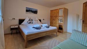 a bedroom with a bed with white sheets and blue pillows at Haus am Stein in Finkenberg