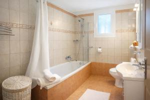 a bathroom with a tub and a toilet and a sink at Villa Aniley in Ratzaklíon +17 photos