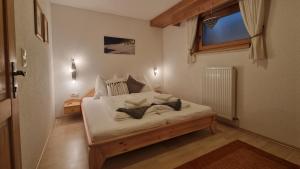 a bedroom with a bed with white sheets and a window at Haus am Stein in Finkenberg +6 photos