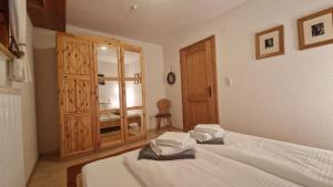a bedroom with a bed and a wooden cabinet at Haus am Stein in Finkenberg