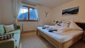 a bedroom with a bed and a couch and a window at Haus am Stein in Finkenberg