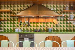 a kitchen with a stove and green and white tiles at Villa privada de lujo Can Riera in Pujals dels Cavallers