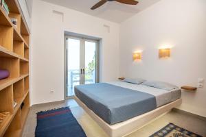 a bedroom with a bed and a large window at Casa Mare Melitsahas - Panoramic Sea View in Kalymnos