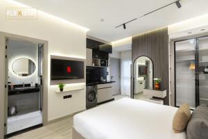 a living room with a white bed and a tv at Flexistay Sheikh Zayed in Sheikh Zayed