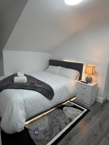 a bedroom with a bed with a lamp and a rug at Bpsairbnbltd in London