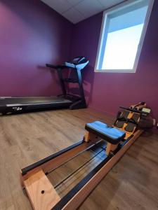a room with a gym with a treadmill and a window at Brit Hotel Vannes - Theix Golfe du Morbihan in Theix