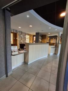 a lobby with a reception desk in a building at Brit Hotel Vannes - Theix Golfe du Morbihan in Theix