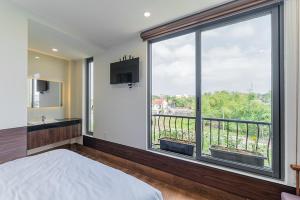 a bedroom with a large window with a bed and a television at Nhà Nghỉ Chiếc Nón in Thôn Dương Xuân Hạ