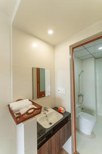 a bathroom with a sink and a toilet and a mirror at Nhà Nghỉ Chiếc Nón in Thôn Dương Xuân Hạ +26 photos