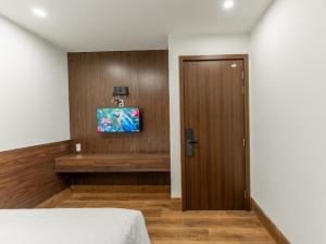 a room with a bed and a tv on a wall at Nhà Nghỉ Chiếc Nón in Thôn Dương Xuân Hạ
