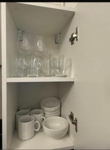 a shelf with bowls and other glass items on it at Studio - Chalon-sur-Saône in Chalon-sur-Saône +13 photos