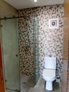 a bathroom with a toilet and a glass shower at Annakhil 30 in Oulad Akkou