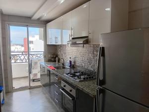 a kitchen with a stainless steel refrigerator and a window at Annakhil 30 in Oulad Akkou