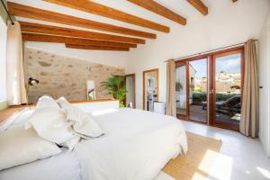 a bedroom with a white bed and a large window at Casa Puresa in Artá