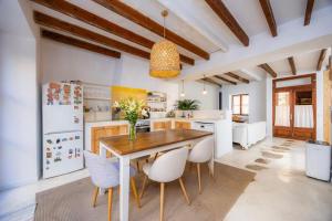 a kitchen with a wooden table and white appliances at Casa Puresa in Artá