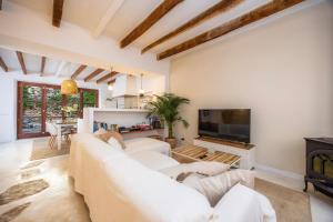 a living room with a white couch and a tv at Casa Puresa in Artá