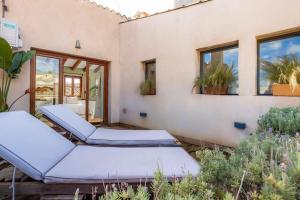 a room with four beds on a patio with plants at Casa Puresa in Artá