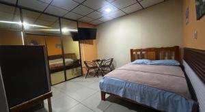 a bedroom with a bed and a table with chairs at Hospedaje Ofe,S #3 in Santiago