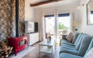 a living room with a blue couch and a red stove at Casa Tossa – Piscina, Vistas Mar y A/C (6 pax) in Tossa de Mar