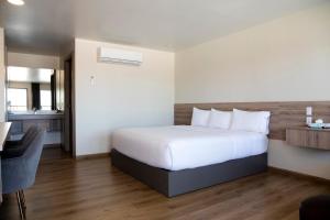 a bedroom with a bed and a desk in a room at La Huerta Inn & Suites in Cuauhtémoc +22 photos
