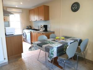 a kitchen with a table and chairs and a kitchen with a table and a table at Gite Chambres d Hotes des Péguets in Faverolles