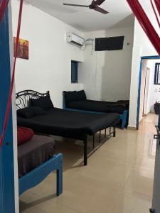 a room with four beds and a ceiling fan at The Maze House Anjuna! in Anjuna