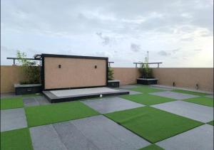 a courtyard with green grass and a building at Casa Dune in Pune