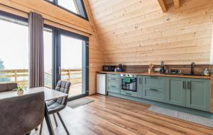 a kitchen with green cabinets and a large window at Confortable Chalet Moderne in Anould