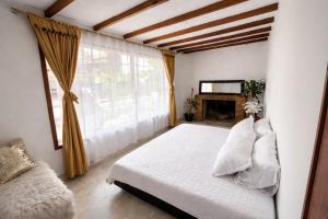 a bedroom with a white bed and a window at Tikki Lua in Cota