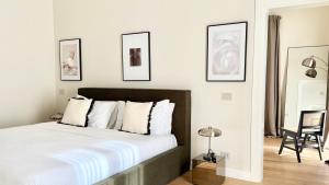 a bedroom with a large bed with four pictures on the wall at Bayab Charming Rooms - Corso Garibaldi in Benevento