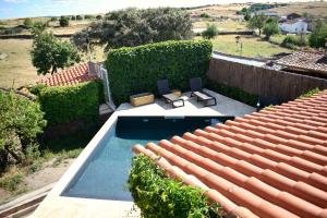 a swimming pool on the roof of a house at Casa Rural El Bornizo con psicina jacuzzi climatizado barbacoa y jardín en Salamanca in Pastores
