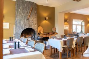 a dining room with tables and a fireplace at B&B - Hotel Le vieux marronnier in Foy-Notre-Dame +42 photos