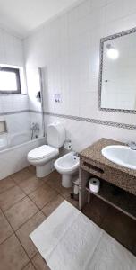 a bathroom with a toilet and a sink and a tub at Quinta das AVES - Double Bedroom 1 in Odiáxere +12 photos