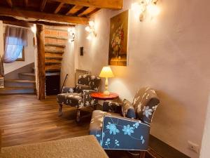 a living room with chairs and a table with a lamp at La Torretta in Laterina