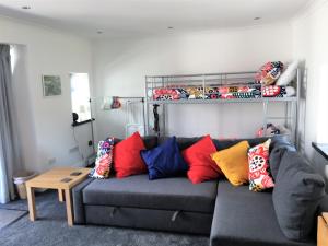 a living room with a gray couch with colorful pillows at Pier Cottage at Kames in Kames