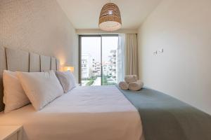 a bedroom with a large bed with a teddy bear on it at Bayline - Bezugo by Bedzy in Armação de Pêra +50 photos