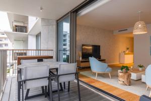 a living room with a dining table and chairs at Bayline - Bezugo by Bedzy in Armação de Pêra