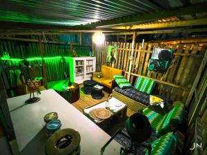 ein Wohnzimmer mit gelbem Sofa und grüner Beleuchtung in der Unterkunft FIIAA in Jaunde