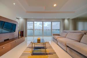 a living room with a couch and a flat screen tv at Unique - Spacious 3BR Premium Flat in Is-Swieqi