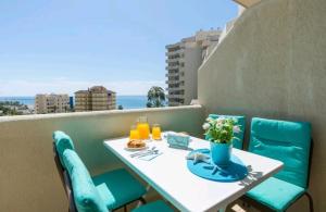 a table and chairs on a balcony with a view at Apartamentos HOLIDAYS BENALBEACH in Benalmádena