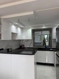 a kitchen with white cabinets and a black counter top at Villa neuve avec une grande terrasse in Dar Tahar Zaouch