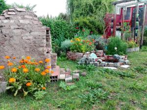 a garden with flowers and a stone fireplace at Habitación en Casa Museo in Villa Garibaldi