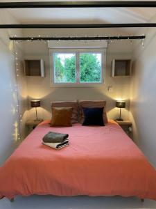 a bedroom with a large orange bed with a window at Chez Sophie in Orléans
